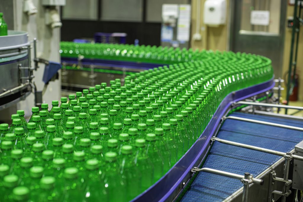 Interior de empresa de bebidas en línea de producción de botellas verdes